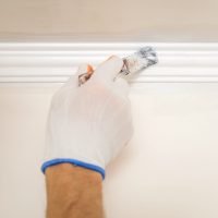 Painting walls and ceilings. Painter paints using a brush